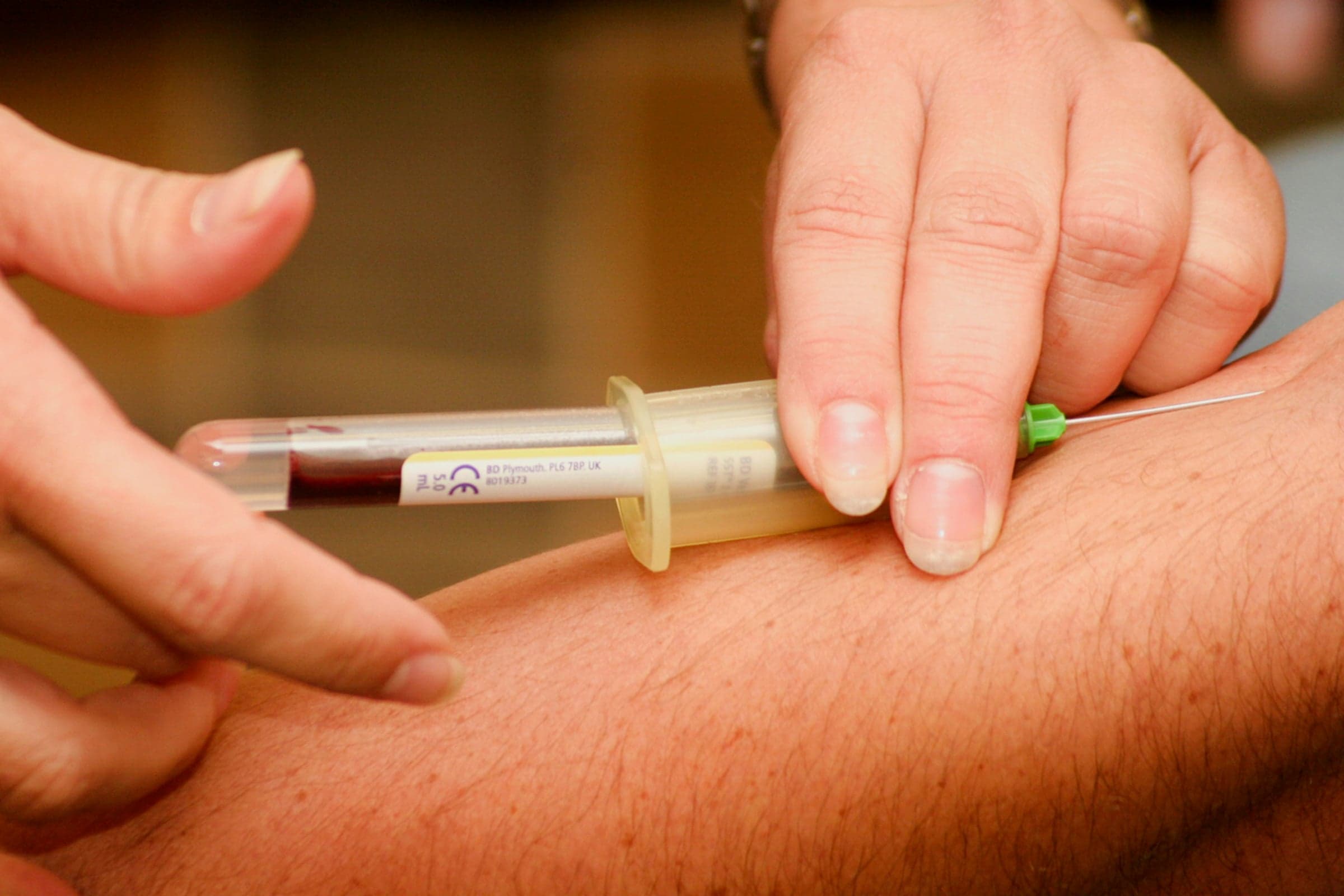 Phlebotomist collecting a blood sample during a home visit
