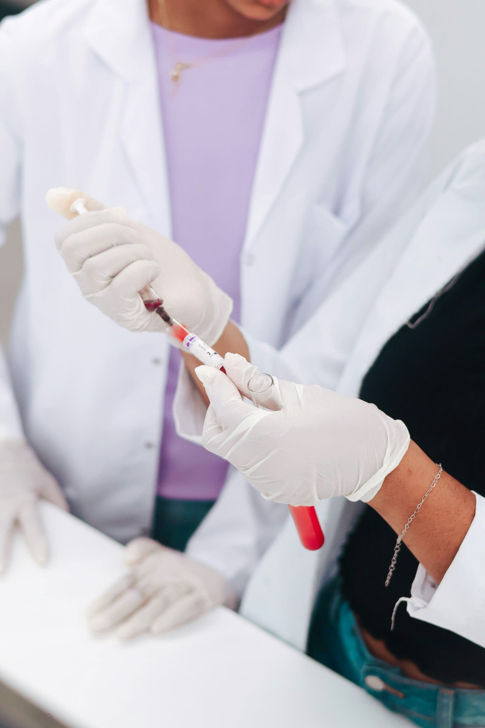 Phlebotomist handling a blood sample tube during specimen collection